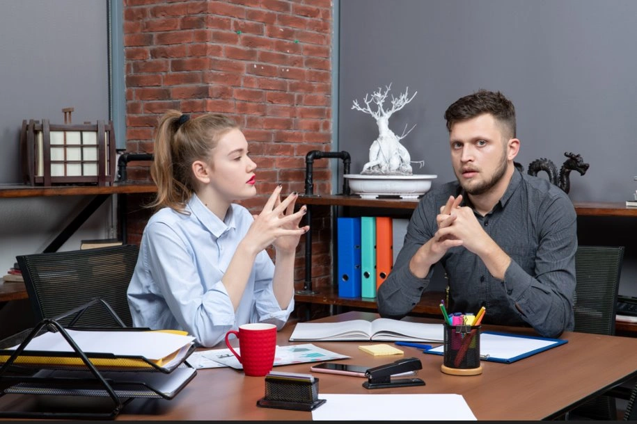 Two professionals discussing speech writing techniques using the rule of three.