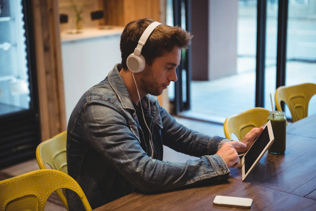 man-listening-music-with-headphones-while-using-digital-tablet (1)