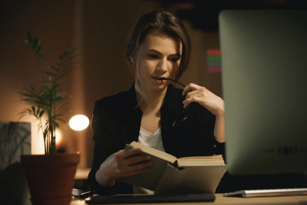 serious-young-lady-designer-reading-book-looking-aside